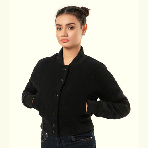 Woman wearing aBlack crop varsity jacket on a white background