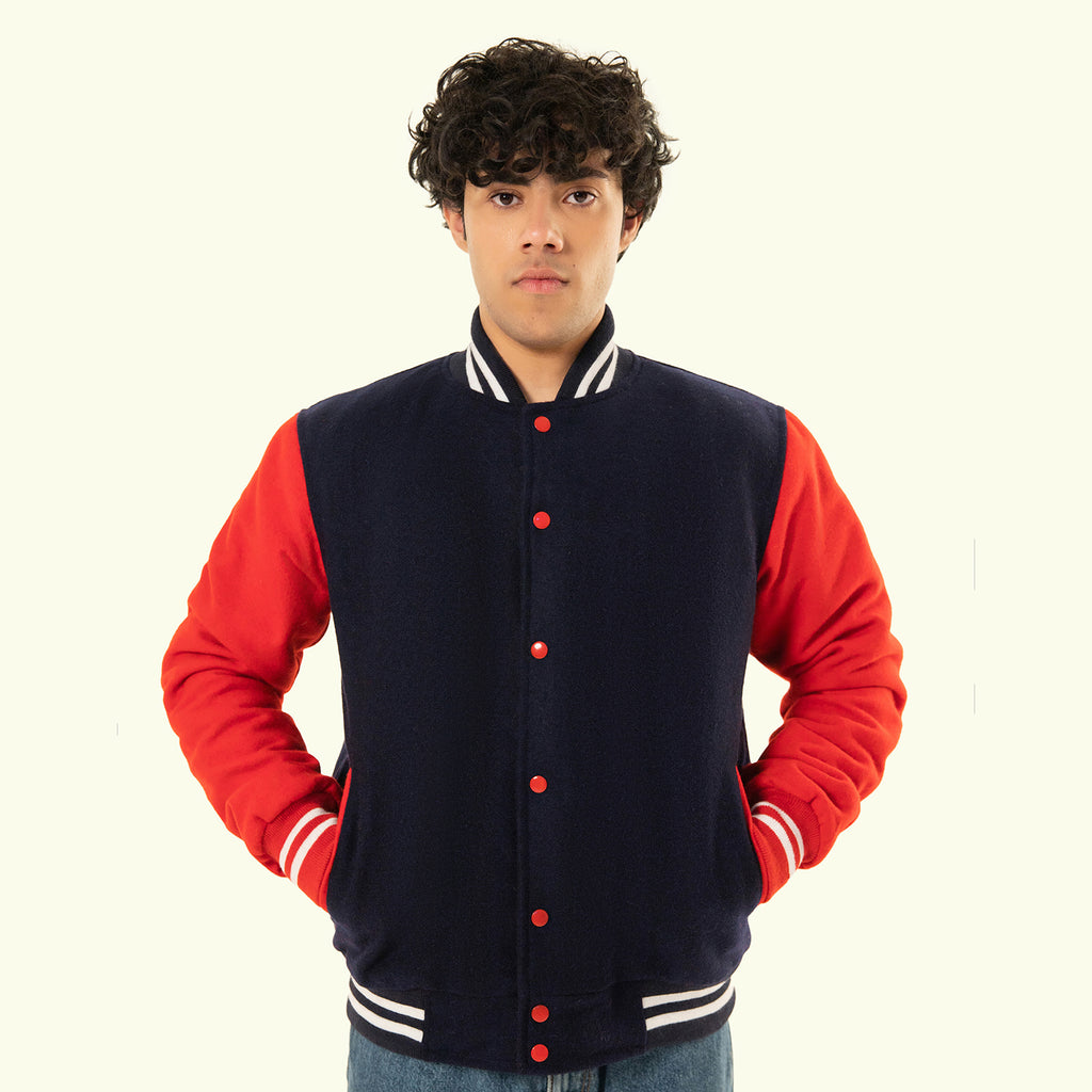 Person wearing a navy and red varsity jacket on a white background