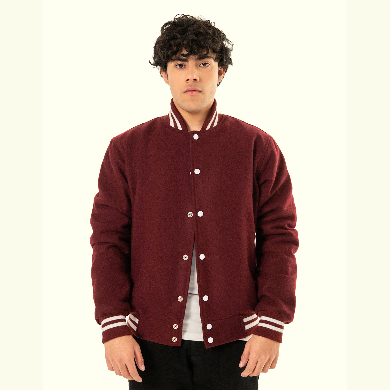 Person wearing a maroon varsity jacket with white buttons and trim on a white background