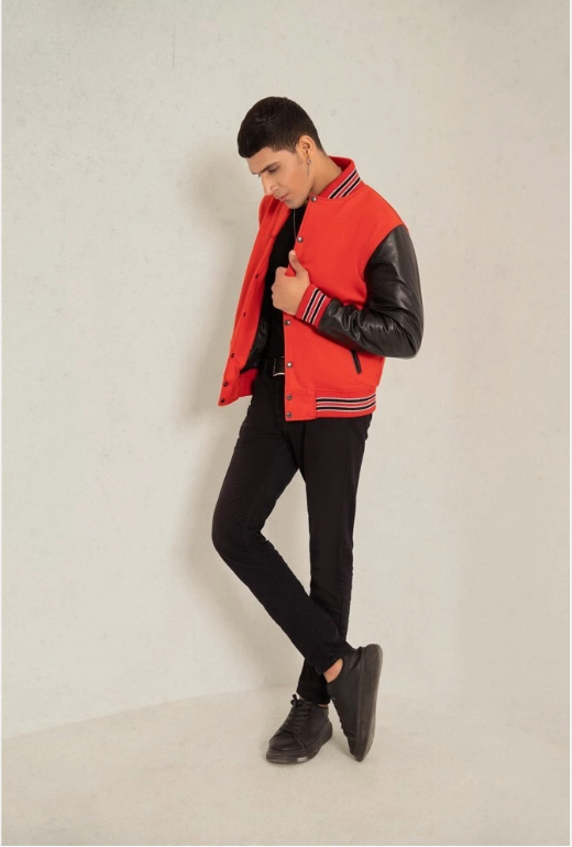 Person wearing a red and black varsity jacket on a plain background