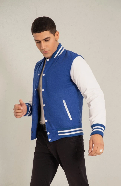 Person wearing a blue and white varsity jacket on a plain background